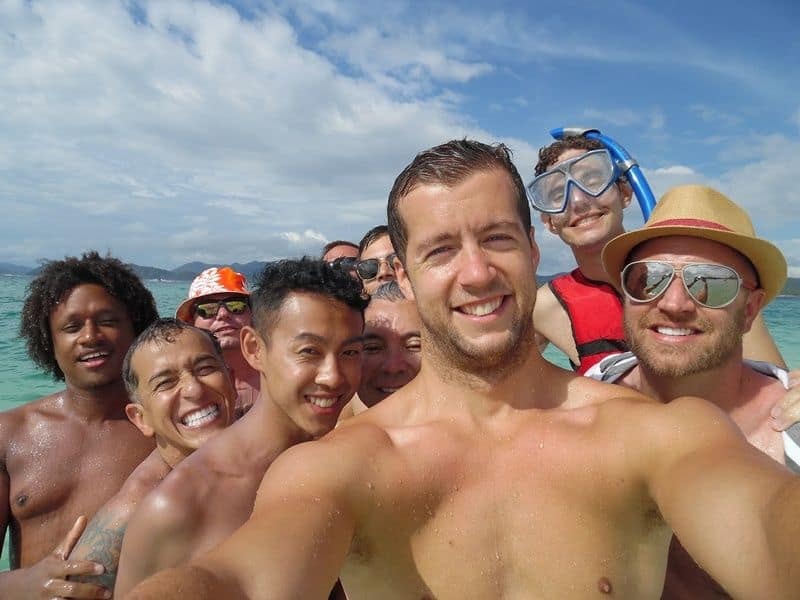 Group of guys celebrating a bachelor trip on a tropical beach