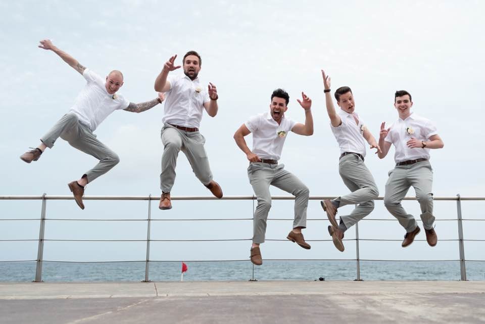 Groomsmen celebrating at a destination bachelor party on the beach