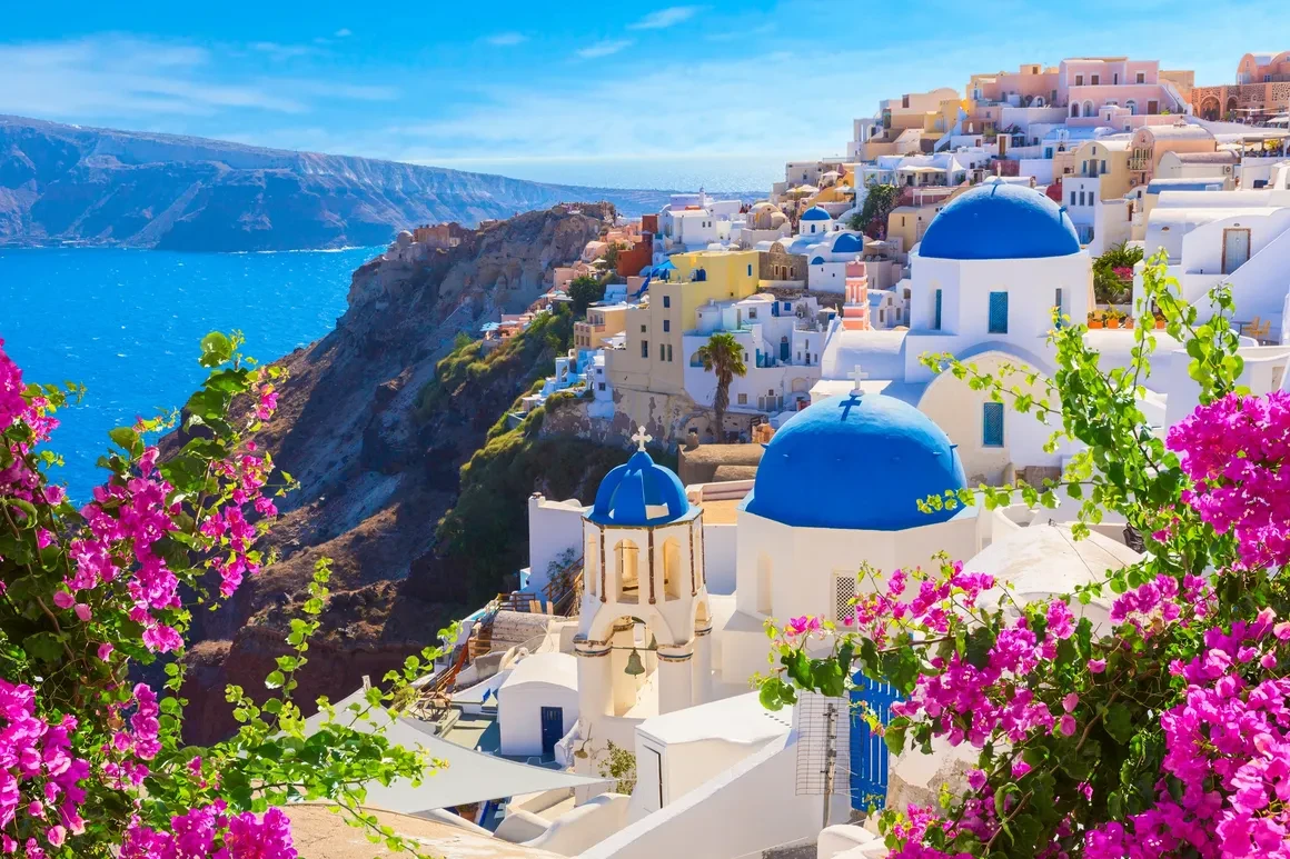 Santorini Greece — white-washed cliffs, blue domes and pink bougainvillea